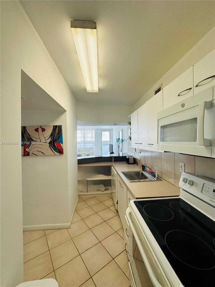 100 Lincoln Road, Unit 1427 Miami Beach, FL 33139 - Photo 12 of 30 a kitchen that has a sink and a stove in it