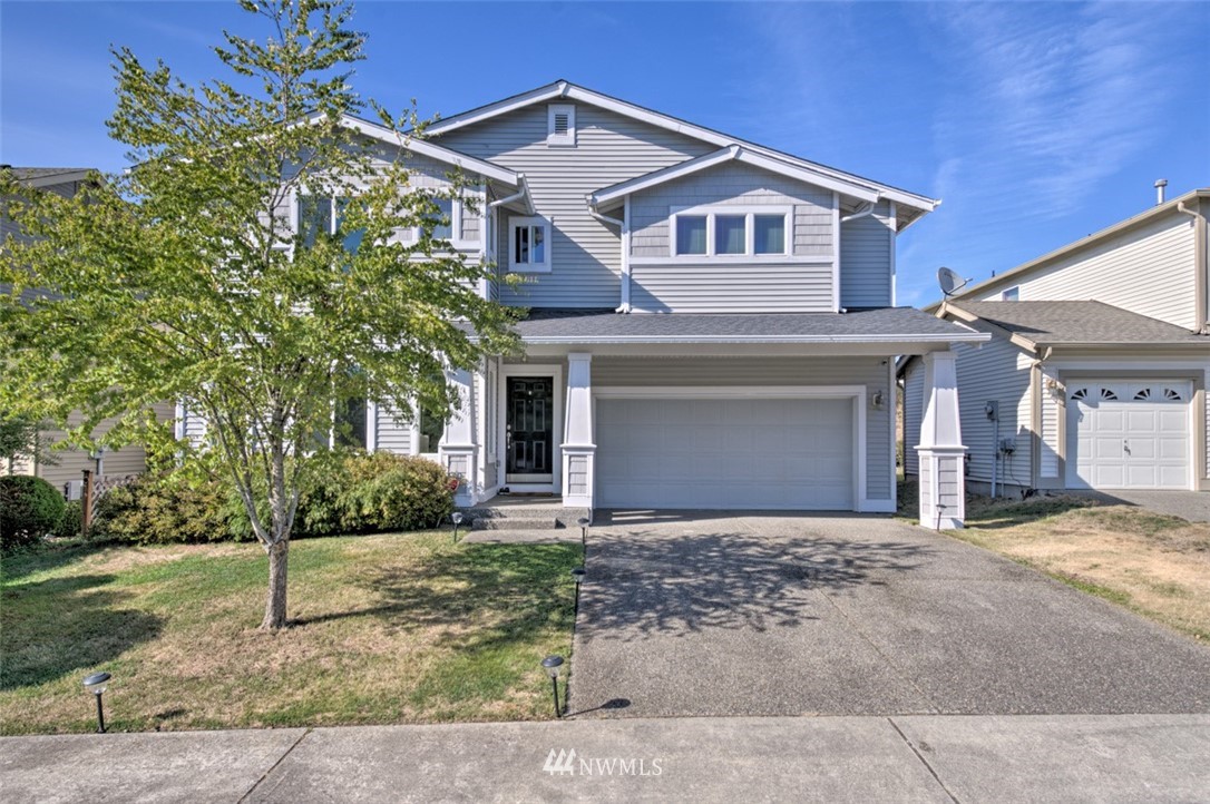 a front view of a house with a yard and garage