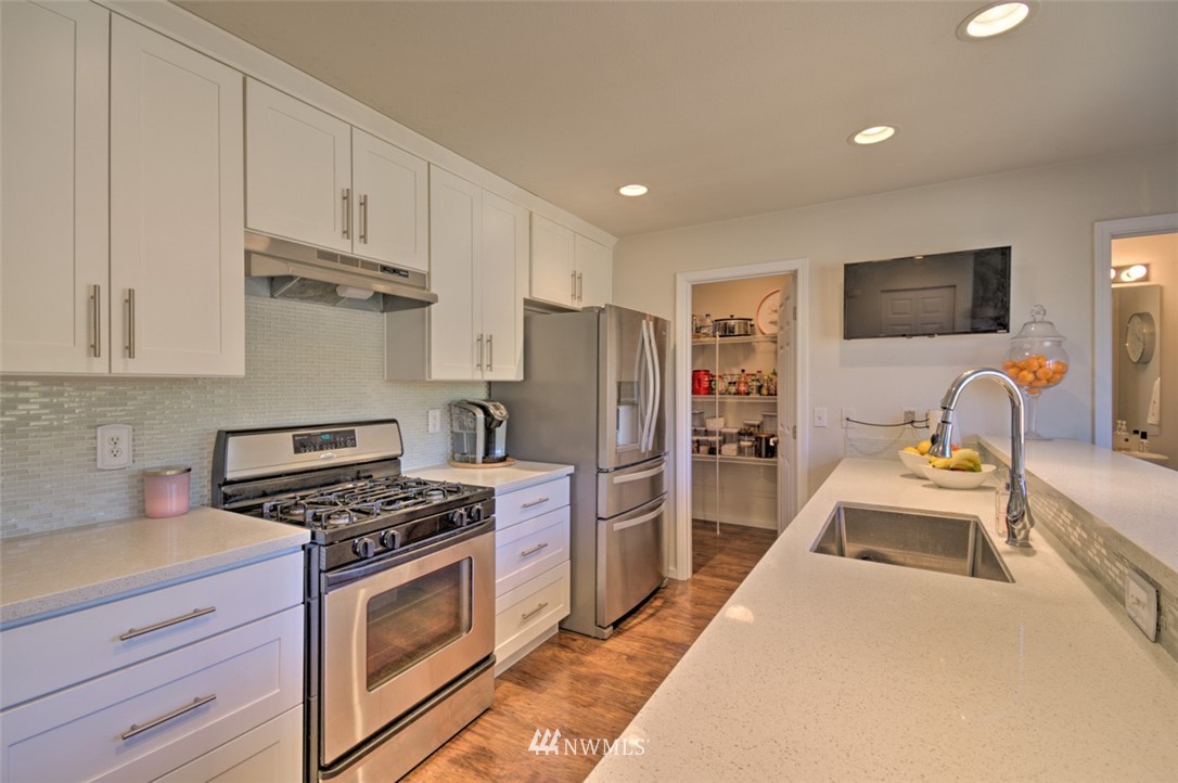 3114 Southeast 3rd Street Renton, WA 98056 - Photo 7 of 25 a kitchen with stainless steel appliances a stove a refrigerator and a sink