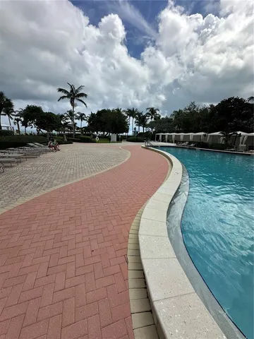 a view of swimming pool with outdoor seating and yard in back