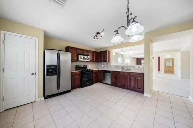a large kitchen with cabinets and stainless steel appliances