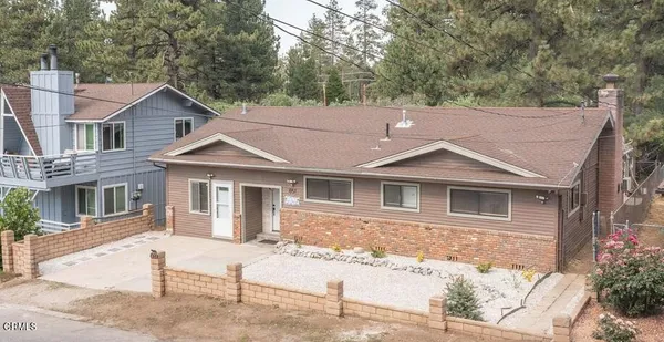 a view of a house with a yard and large tree