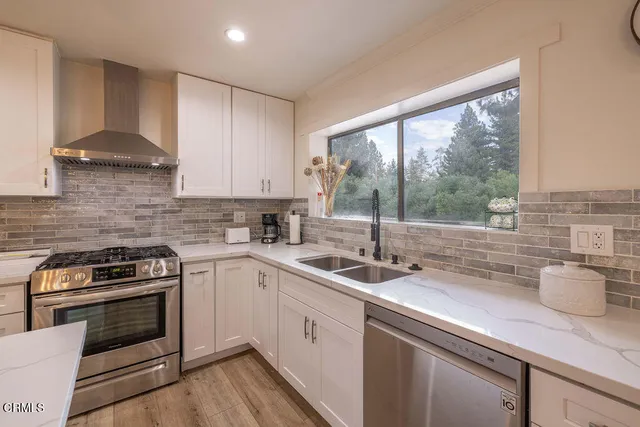 a kitchen with stainless steel appliances a stove a refrigerator a sink and cabinets