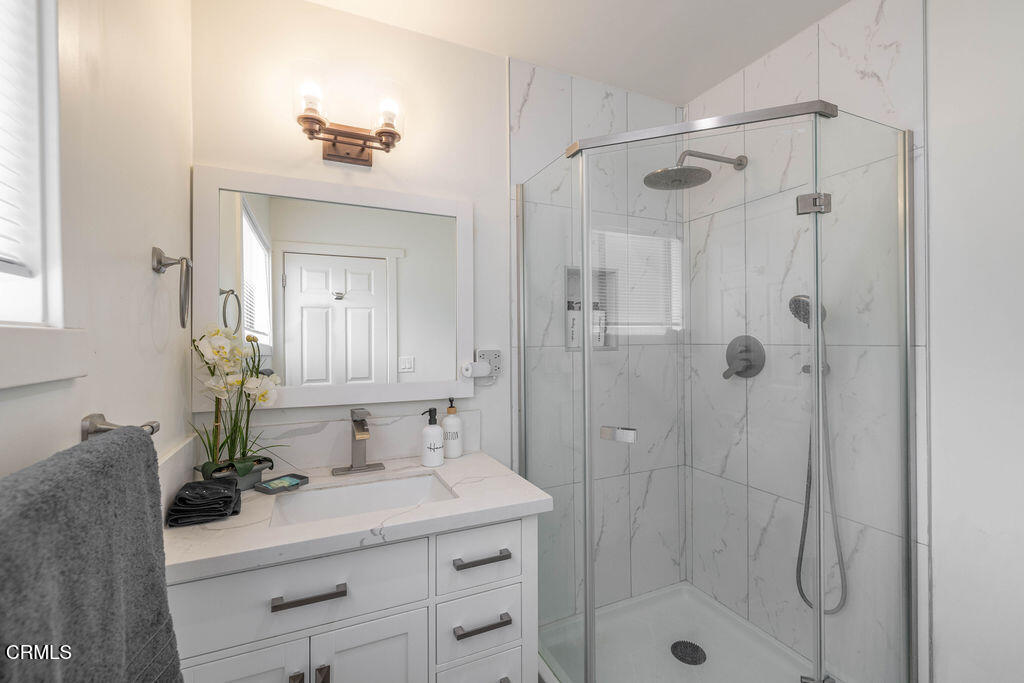 851 Pine Knot Avenue Big Bear Lake, CA 92315 - Photo 15 of 27 a bathroom with a shower sink vanity and mirror