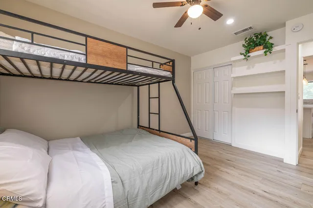 a bedroom with a bed and a chandelier fan