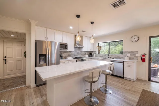 a view of a living room kitchen and a wooden floor