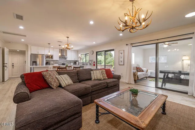 a living room with furniture a fireplace and a chandelier