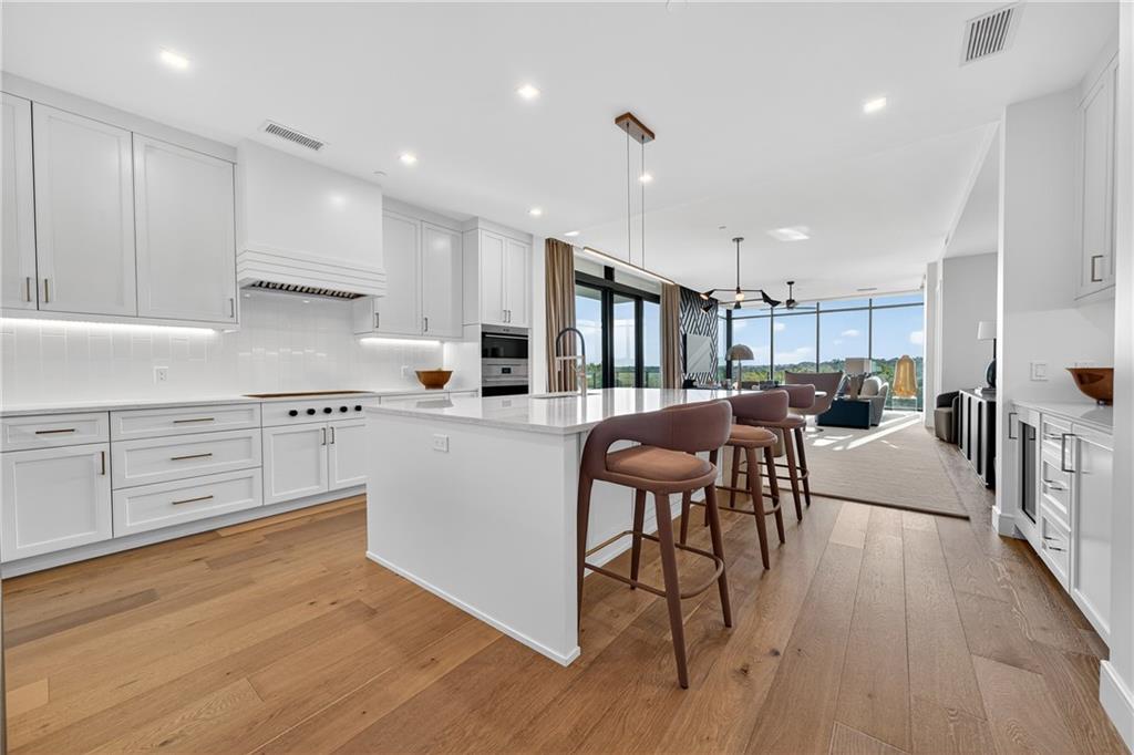 2520 Peachtree Road Northwest, Unit 903 Atlanta, GA 30305 - Photo 12 of 62 a kitchen with white cabinets and chairs