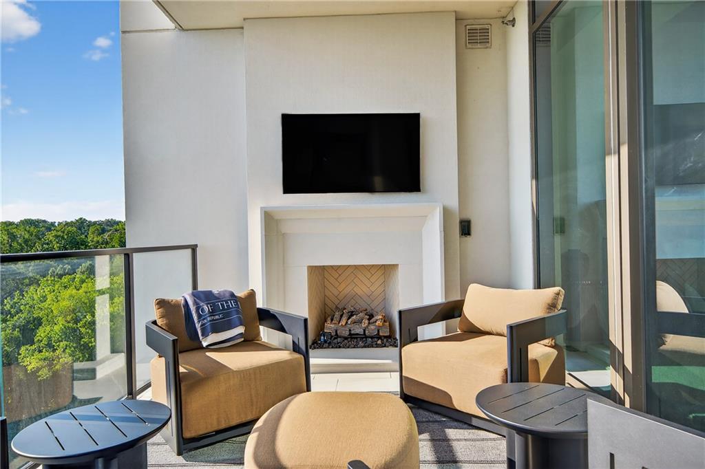 2520 Peachtree Road Northwest, Unit 903 Atlanta, GA 30305 - Photo 6 of 62 a living room with furniture a flat screen tv and a fireplace