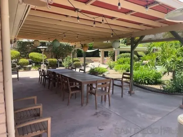 a view of a patio with table and chairs potted plants