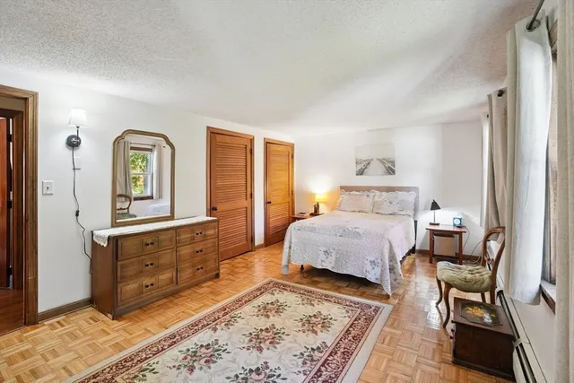 a spacious bedroom with a bed and wooden floor
