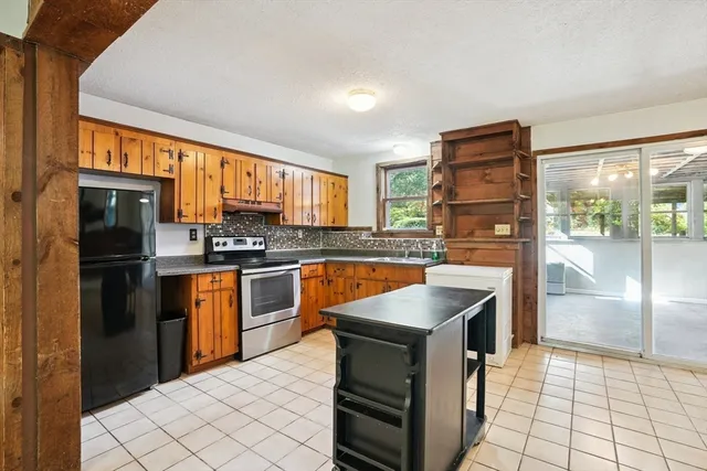 a kitchen with granite countertop a refrigerator stove and oven