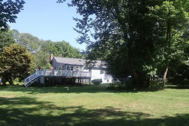 a view of a house with a yard balcony and tree