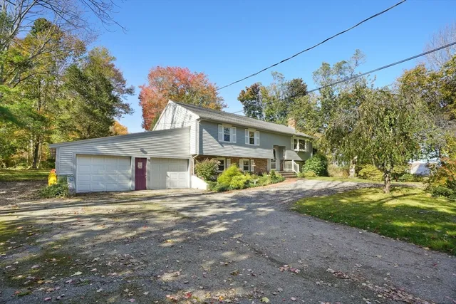 a view of a house with a big yard and large tree