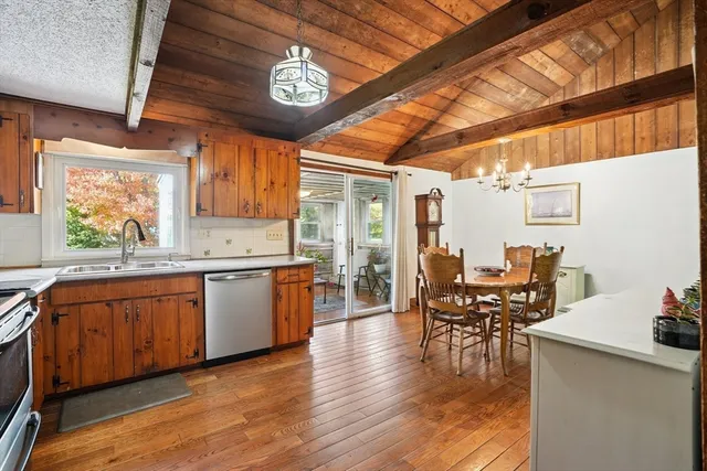 a kitchen with stainless steel appliances granite countertop wooden floors a stove and white cabinets