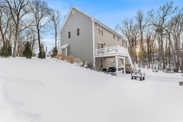 a front view of a house with a yard covered in snow