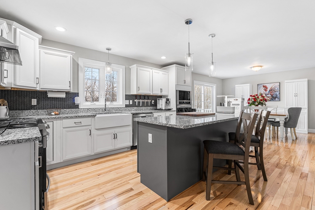 29 Dawley Road Westminster, MA 01473 - Photo 3 of 30 a kitchen with kitchen island granite countertop a sink a stove a dining table and chairs