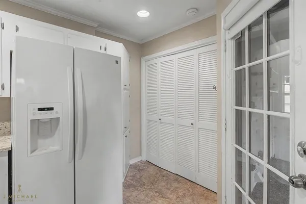 a kitchen with granite countertop white cabinets white stainless steel appliances and a sink