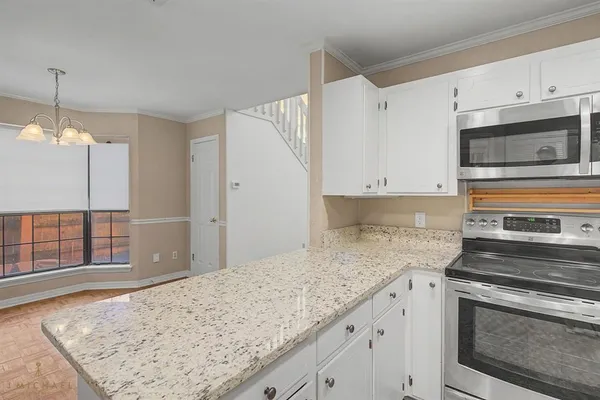 a kitchen with granite countertop cabinets stainless steel appliances and a counter space