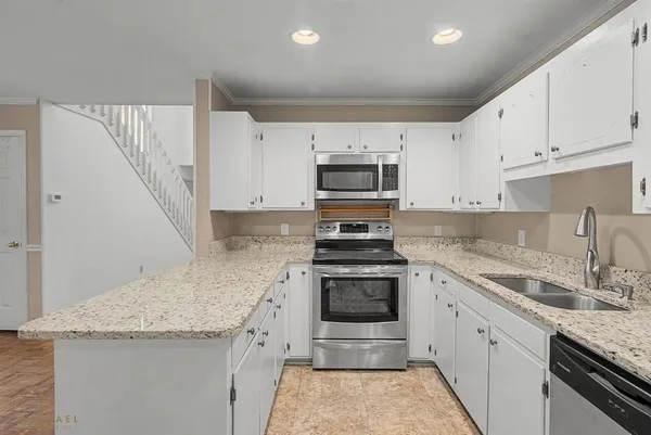 a kitchen with granite countertop a sink stove and cabinets