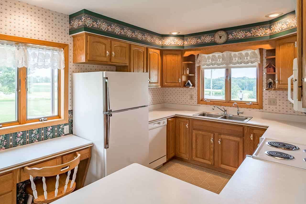 10208 Center Road Durand, IL 61024 - Photo 15 of 25 a kitchen with stainless steel appliances granite countertop a refrigerator a sink dishwasher a stove and white countertops with wooden floor