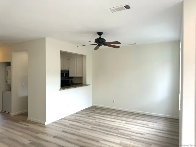 a view of a room with wooden floor and a ceiling fan