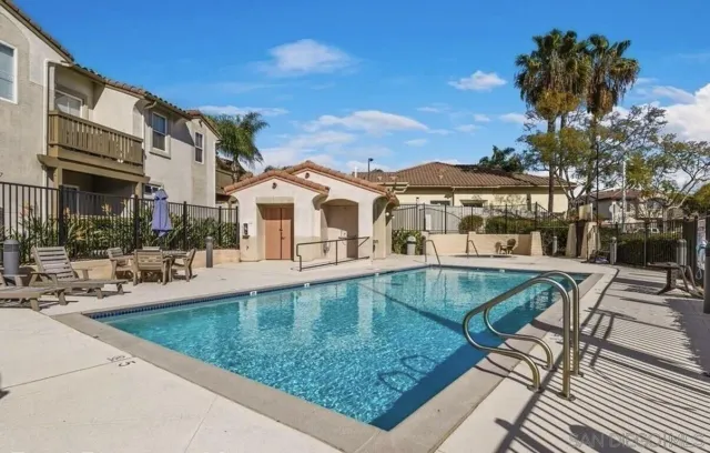 a view of a white house with a swimming pool and sitting area