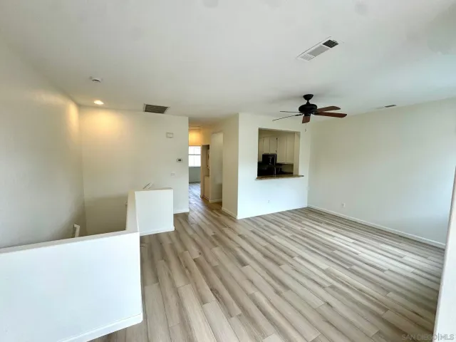 a view of a big room with wooden floor and windows