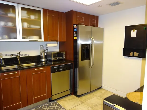 a kitchen with stainless steel appliances granite countertop a refrigerator and a stove