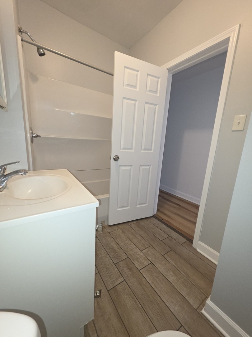 5816 West Chicago Avenue, Unit 2 Chicago, IL 60651 - Photo 5 of 10 a bathroom with a sink and toilet
