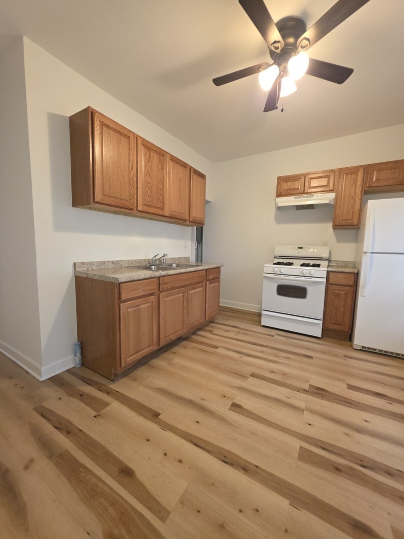 5816 West Chicago Avenue, Unit 2 Chicago, IL 60651 - Photo 8 of 10 a kitchen with stainless steel appliances granite countertop a refrigerator and a stove top oven