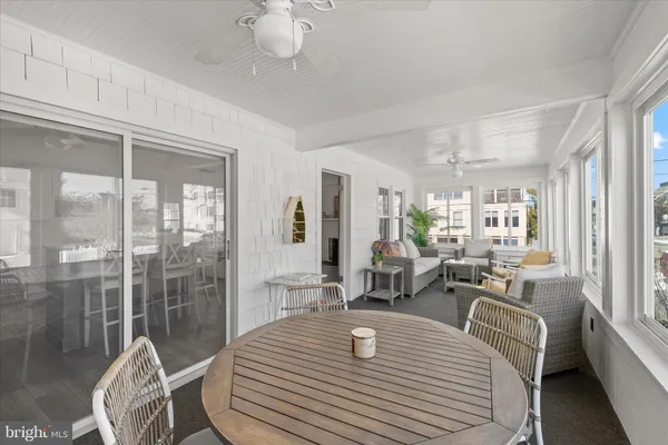 a dining room with furniture and a floor to ceiling window