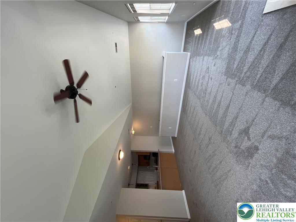 Soaring vaulted ceilings and soft carpeting define this open living area.