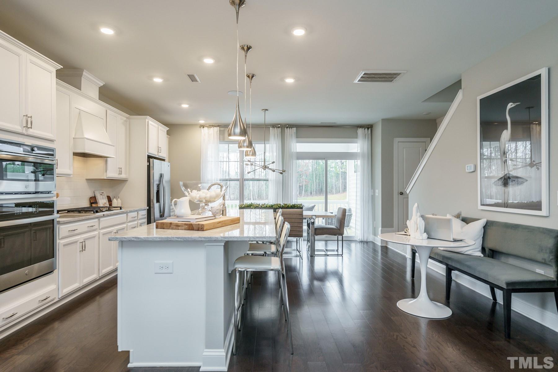 2225 Kettle Falls Station, Unit 392 Apex, NC 27502 - Photo 26 of 52 a kitchen with stainless steel appliances granite countertop a stove and a wooden floors