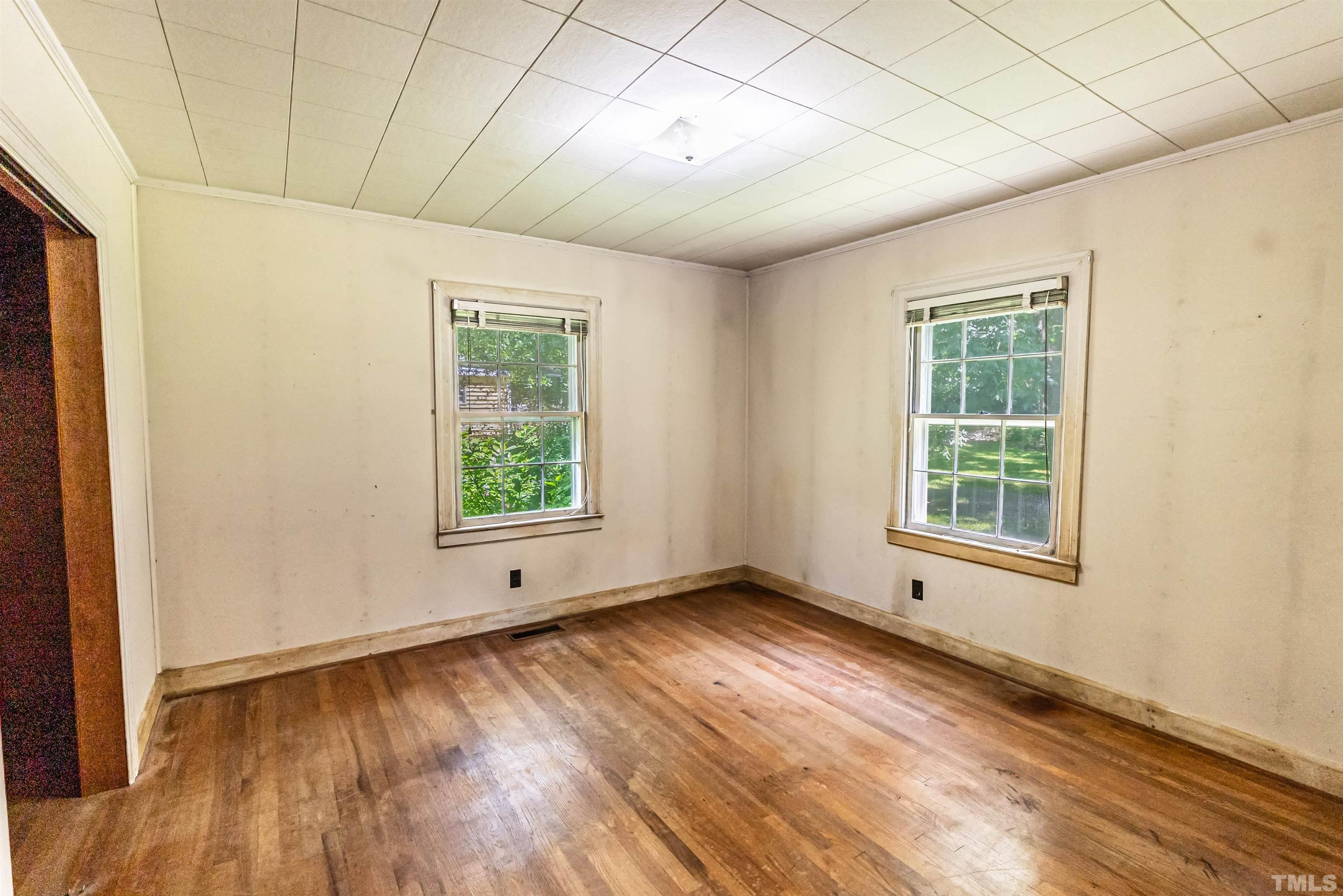 457 Rose Lane Raleigh, NC 27610 - Photo 12 of 26 a view of an empty room with wooden floor and a window