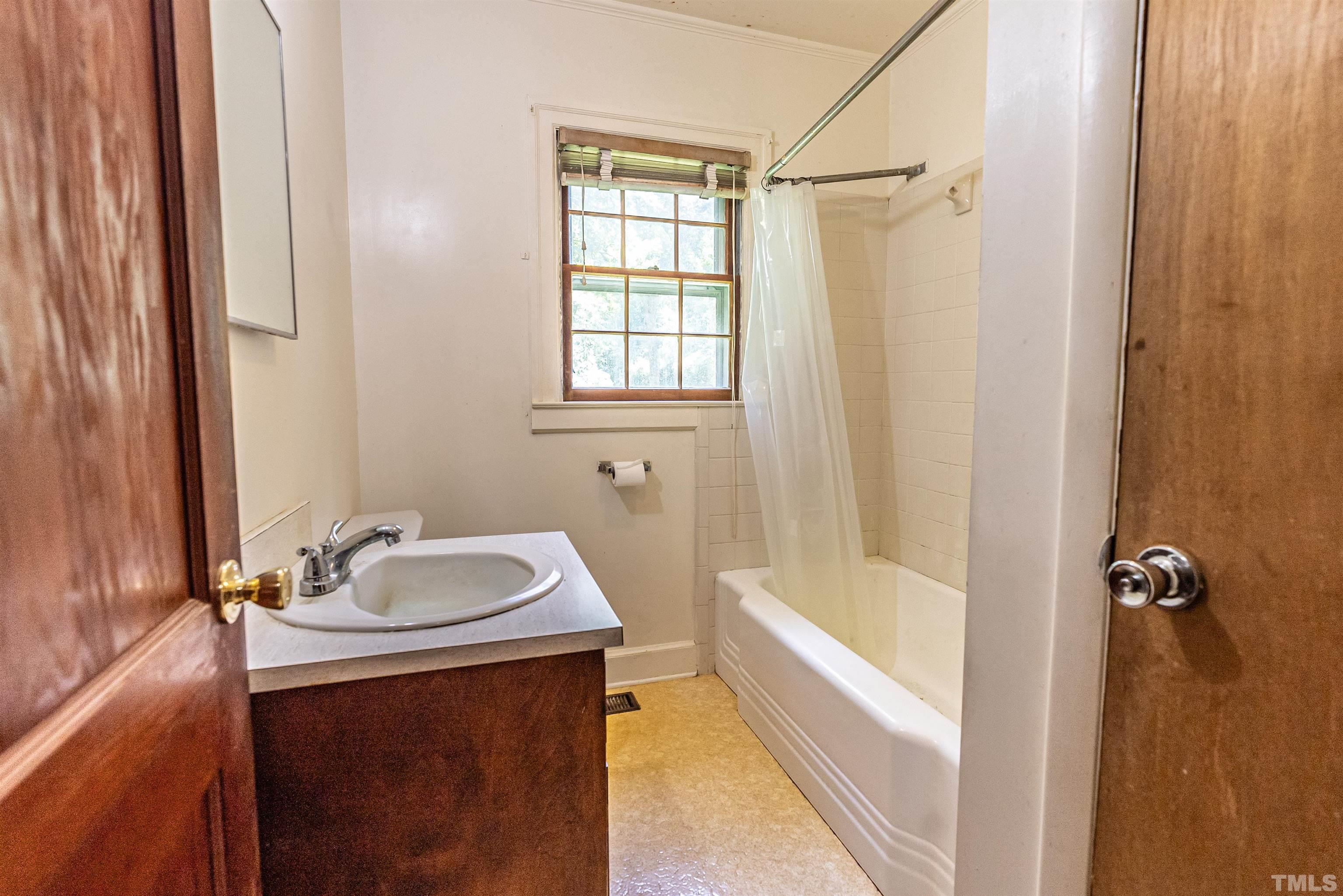457 Rose Lane Raleigh, NC 27610 - Photo 14 of 26 a bathroom with a sink a bathtub and a shower