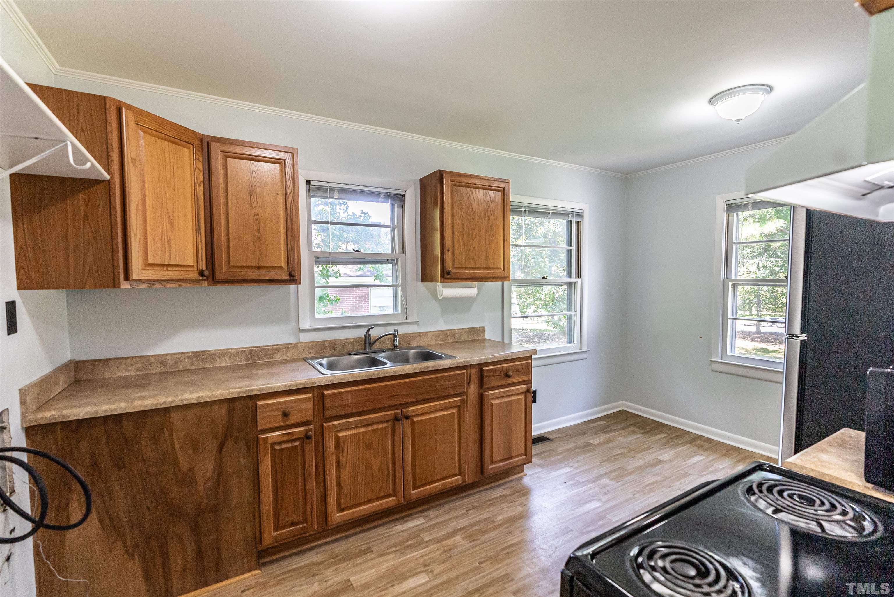 457 Rose Lane Raleigh, NC 27610 - Photo 10 of 26 a kitchen with a sink and wooden cabinets