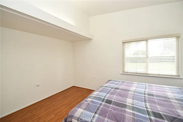 a living room with furniture and a dining table with wooden floor