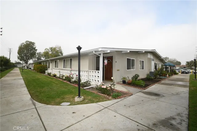 a front view of white house with a yard