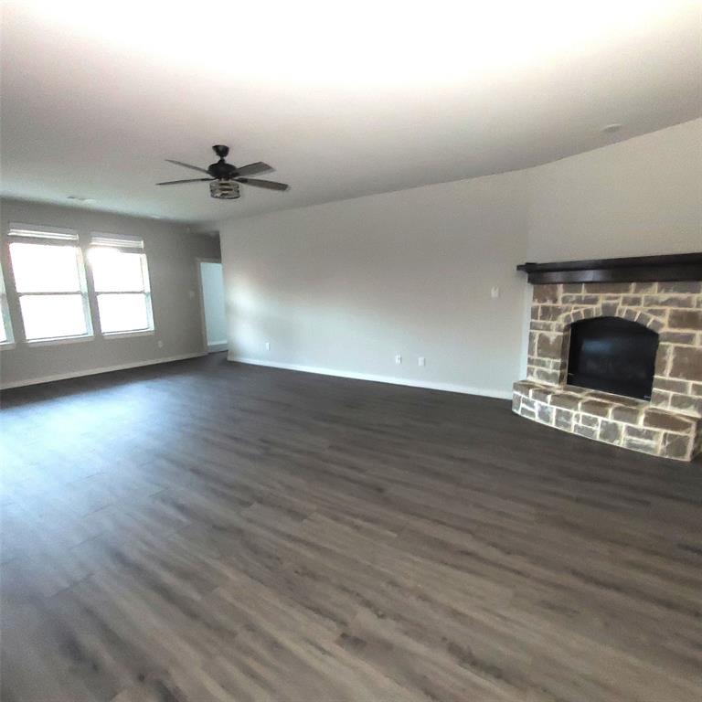 1813 Huntsman Way Forney, TX 75126 - Photo 3 of 18 an empty room with wooden floor fireplace and windows
