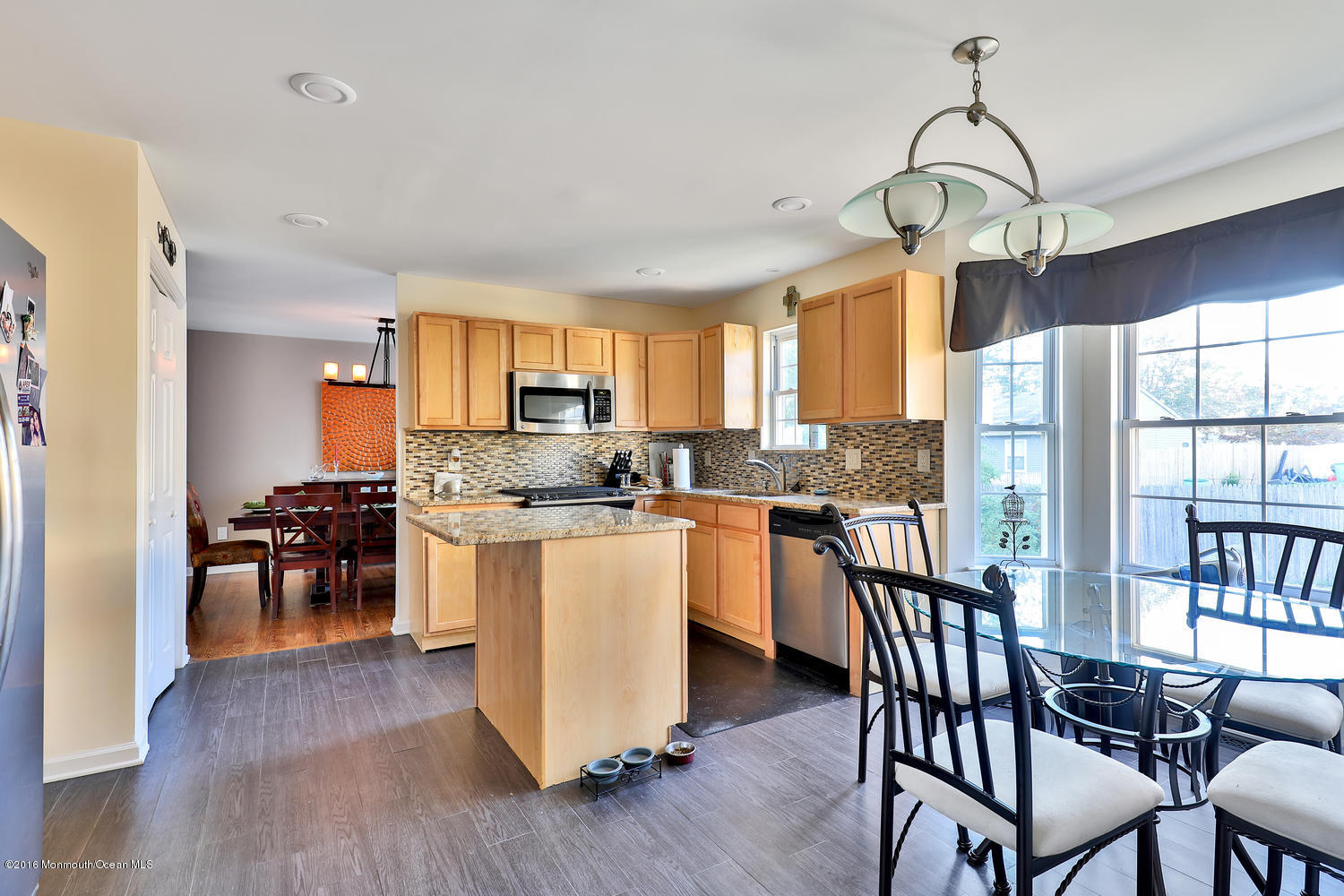 112 Seaspray Road Manahawkin, NJ 08050 - Photo 6 of 21 a kitchen with stainless steel appliances granite countertop wooden floor a dining table and chairs