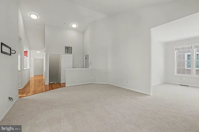 a view of an empty room with a window and a bathroom