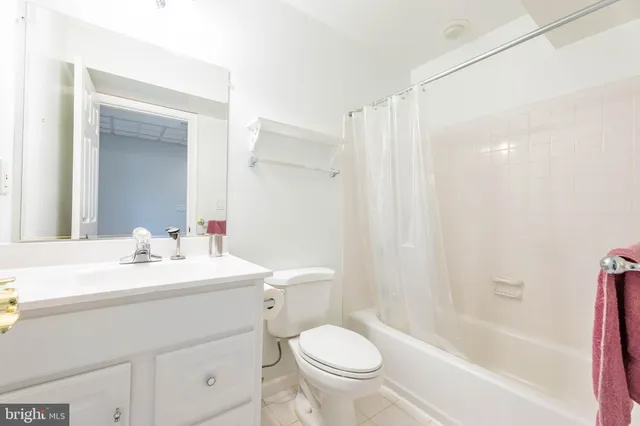 a view of an empty room with kitchen and a window