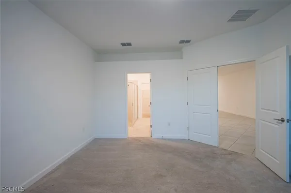a bedroom with a bed and a lamp on the dresser