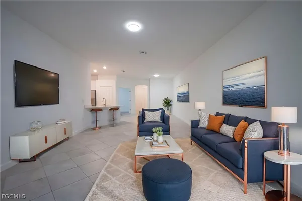a view of a big room with windows and chandelier fan
