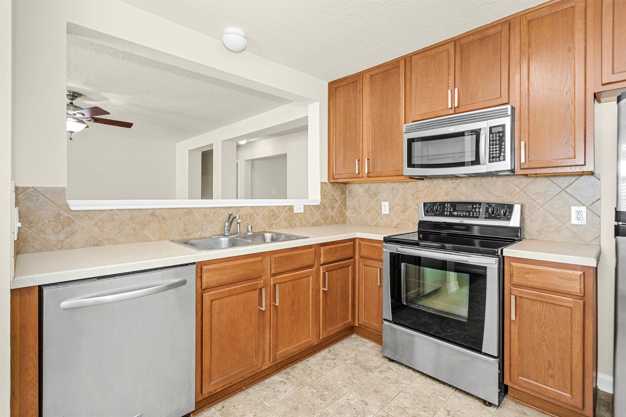 3131 Beacon Grove Street Spring, TX 77389 - Photo 13 of 38 a kitchen with stainless steel appliances granite countertop a sink stove and microwave