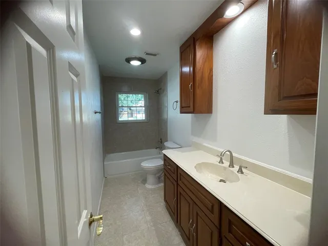 a kitchen with granite countertop a sink a stove and cabinets