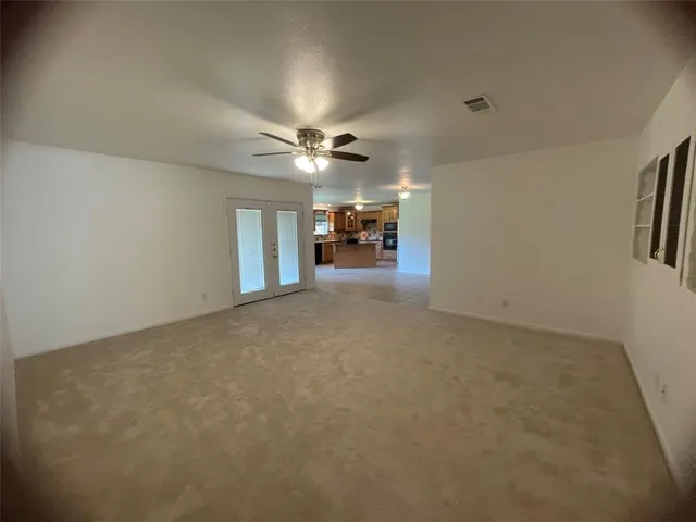 an empty room with furniture and a ceiling fan