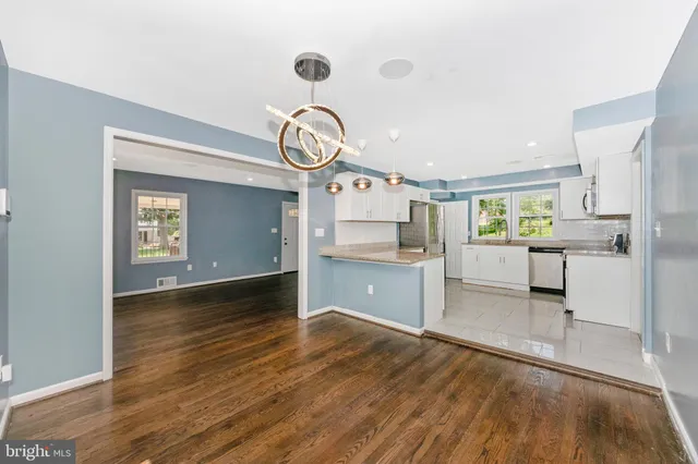 a view of a kitchen with wooden floor and cabinets