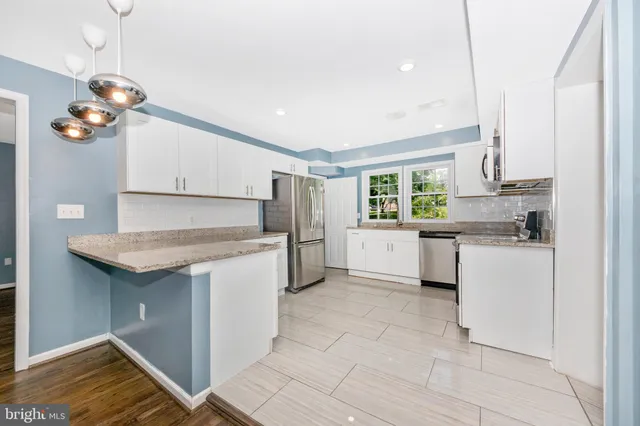 a kitchen with a refrigerator and white cabinets